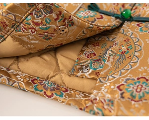 Close-up of golden brocade fabric with traditional floral patterns and quilted lining