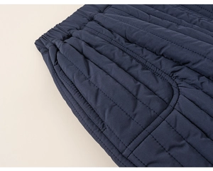 Detail of dark blue quilted winter pants featuring elastic waistband and side pockets