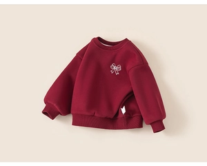 Détail d'un sweat en polaire rouge avec broderie nœud blanc et doublure chaude intégrée