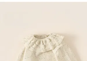 Detail of ruffled round neck and knit texture on this warm beige children top