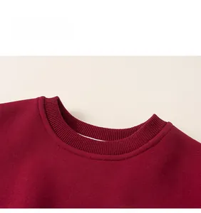 Détail du col rond côtelé et de la doublure en polaire rouge épaisse du sweat enfant