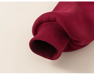Gros plan détaillé sur les poignets côtelés bordeaux d'un sweat-shirt d'hiver épais