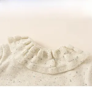 Detail of oatmeal knit sweater featuring a ruffled lace collar and colorful flecked yarn
