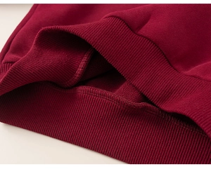 Détail d'un sweat à capuche rouge foncé pour enfant avec doublure polaire et bord côtelé