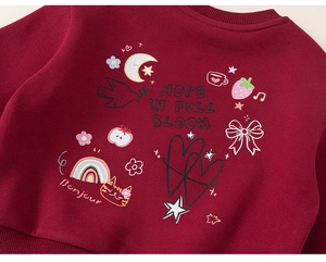 Détail d'un sweat rouge pour enfant avec imprimés lune et fraises en coton doux