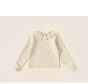Detail of toddler girl thermal knit top featuring delicate ruffled collar and thick texture
