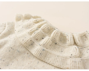 Close-up of warm knit sweater featuring colorful nep yarn and ruffled collar detail