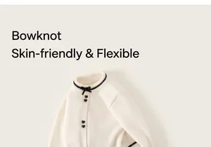 Detail der cremefarbenen Strickjacke mit schwarzen Herzknöpfen und Zierschleife