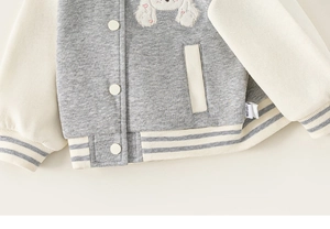 Détail de veste baseball enfant en tricot gris avec broderie de chiot blanc