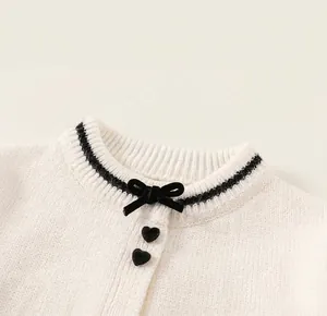 Details des Strickpullover-Kragens mit Samtschleife und Herzknöpfen aus Metall