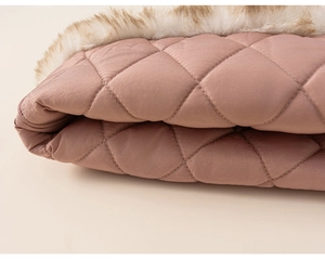 Detail of pink quilted girls' vest featuring soft faux fur trim and diamond stitch pattern