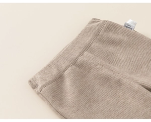 Close-up of baby ribbed knit pants showing the elastic waist and detailed fabric texture