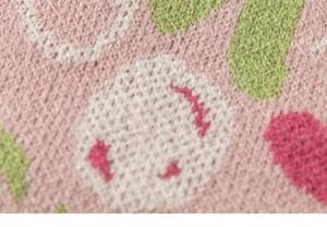 Detailaufnahme von rosa Strickwaren mit weicher Jacquard-Mustermaserung für Kinder