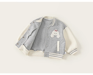 Détail d'une veste baseball enfant avec broderie chiot et boutons-pression en métal