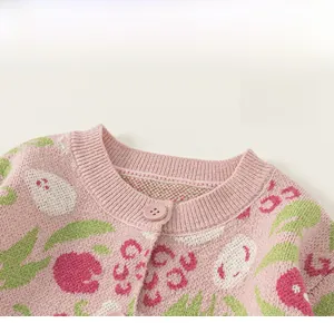 Detail der rosa Strickjacke am Ausschnitt mit rotem Tulpen-Jacquard und Harzknöpfen