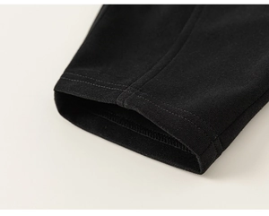 Detailansicht der schwarzen Kinderhose mit verstärktem Saum und feiner Stricktextur aus Baumwolle