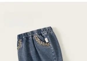 Gros plan d'un pantalon denim fille avec poche léopard et taille élastique souple