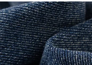 Gros plan sur la texture du denim bleu foncé et les détails du tissage sergé classique