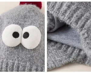 Macro detail of grey knit baby hat featuring cartoon eyes and soft warm inner lining