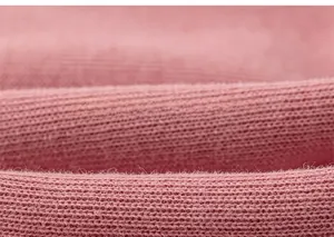Makroaufnahme von weichem rosa Strickstoff mit Erdbeer-Stickerei-Details