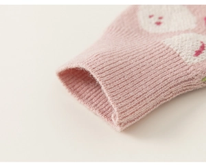 Detail von rosa Strickärmeln mit Rippbündchen und bunten Blumen-Jacquard-Mustern
