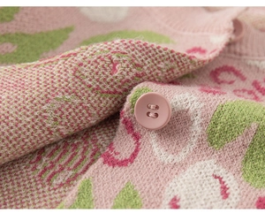Detailansicht der rosa Strickjacke mit Jacquard-Blumenmustern und passendem runden Knopf