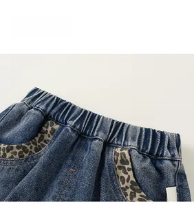 Détail de jean pour enfant avec taille élastique et finitions de poche à motif léopard