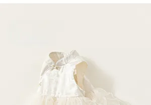 Detail of floral jacquard fabric and delicate gold bow on kids white tulle dress