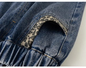 Détail de poche avec imprimé léopard et taille élastique sur un jean bleu pour petite fille