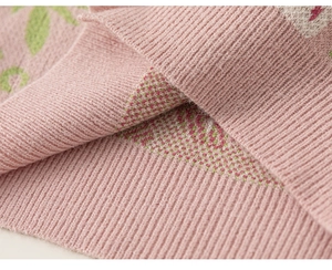 Detail des Rippsaums am hellrosa Strickpullover für Mädchen mit grünen Blattmustern