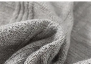 Détail de la maille torsadée grise montrant la texture douce de la laine et le tissage