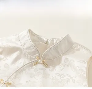 Macro detail of mandarin collar with pearl bow and floral jacquard fabric