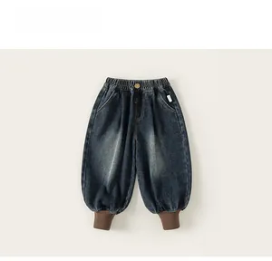 Detailed view of elastic waist and ribbed cuffs on kids dark blue washed denim joggers