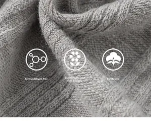Gros plan sur tissu gris en maille torsadée montrant la texture douce et respectueuse