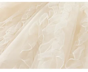 Detail of layered tulle hem with wavy edges on a light beige girl's princess tutu dress