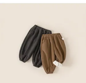 Detail of children's fleece lined pants showing warm lining and ribbed texture in grey and brown