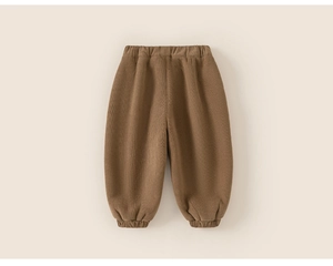 Detail of warm tan children's lantern pants with elastic waist and textured fabric