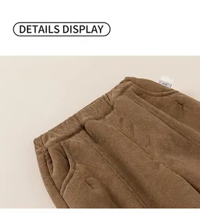Detail view of elastic waist and side pockets on brown corduroy trousers for kids