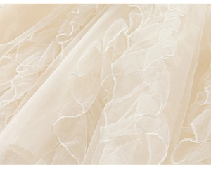 Close-up of soft cream layered mesh fabric with delicate ruffles for girls' cake dress
