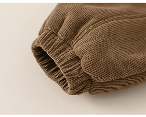 Close-up of thick brown ribbed knit cuffs on kids winter pants showing warm texture