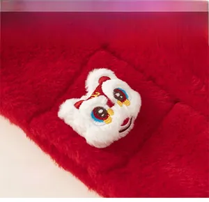 Détail d'écharpe en fausse fourrure rouge avec broderie de lion dansant en 3D