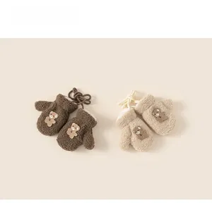 Detailed view of plush lamb wool baby mittens with soft fleece lining and bear embroidery