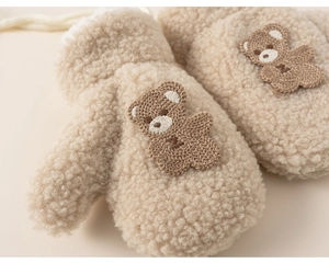 Close-up of plush warm mittens with cute bear embroidery and anti-lost string