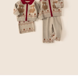 Detail of oatmeal knit cardigan and pants featuring teddy bear patches and nordic patterns