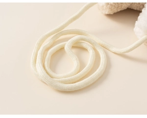 Detailed close-up of soft white plush fleece material and woven lanyard on winter glove