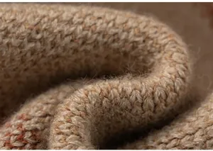 Macro view of knit fabric detail showing beige and orange woven texture and soft fibers