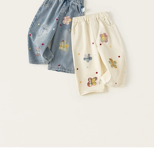 Detalle de pantalones anchos para niña con bordado floral colorido y cintura elástica