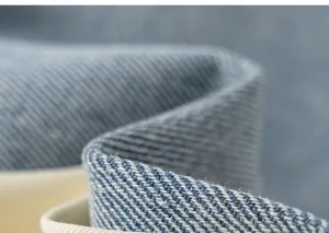 Primer plano de tela vaquera azul que muestra el tejido de sarga y costuras blancas