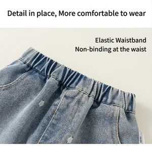 Detalle de pantalones vaqueros azules para niños con estampados de corazones y cintura