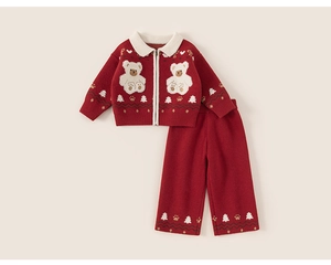 Detail of red knit kids set showing white bear patches and festive tree jacquard patterns